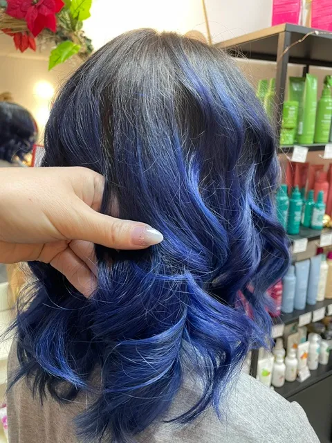 Cheveux mi-longs ondulés avec une coloration bleu profond.