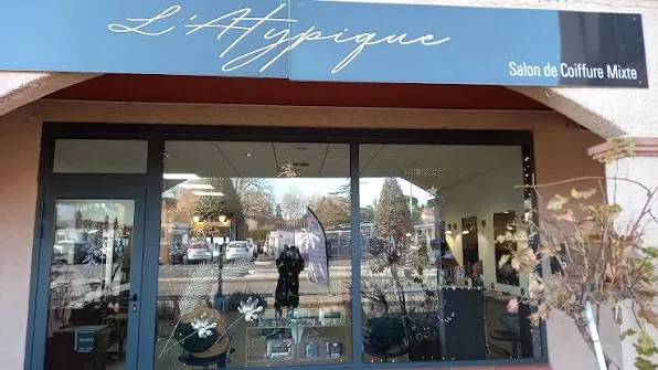 Devanture vitrée de L'Atypique avec son enseigne bleu clair « Salon de Coiffure Mixte ».