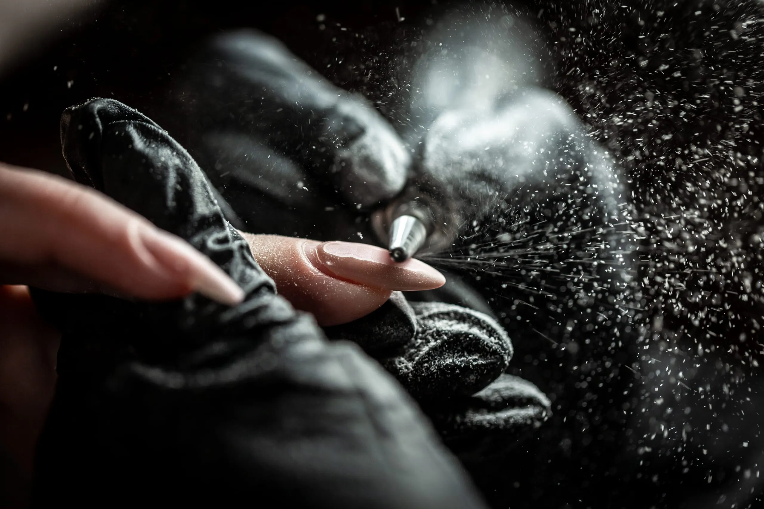 Travail d'un ongle en gel à la ponceuse électrique par une professionnelle de la manucure.